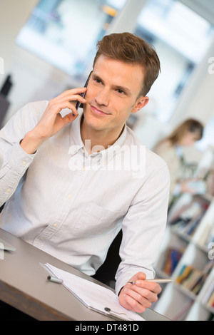 Man Cheerful desk cell phone young Stock Photo