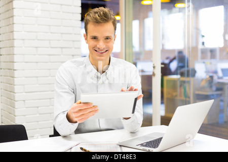 Man business tablet pc desk laptop message e-mail looking camera Stock Photo