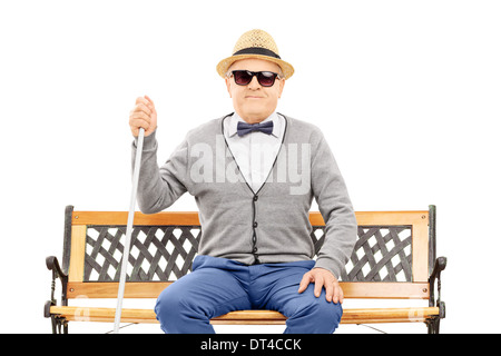 Blind senior man seated on bench Stock Photo
