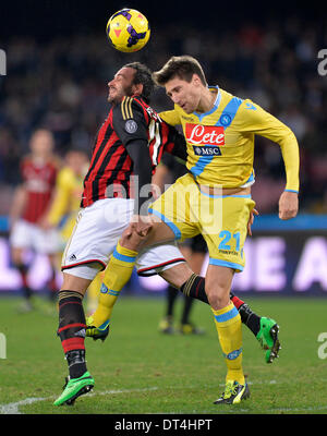 Naples, Italy. 8th Feb, 2014. AC Milan's Gianpaolo Pazzini (L) vies for the ball with Napoli's Federico Fernandez during their Italian Serie A soccer match at San Paolo stadium in Naples, Italy, Feb. 8, 2014. Napoli won 3:1. Credit:  Alberto Lingria/Xinhua/Alamy Live News Stock Photo