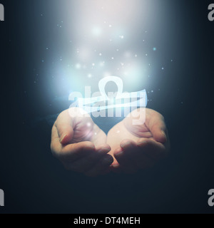 Female hands opening to light and holding zodiac sign for Libra. Horoscope symbols. Selective focus. Stock Photo