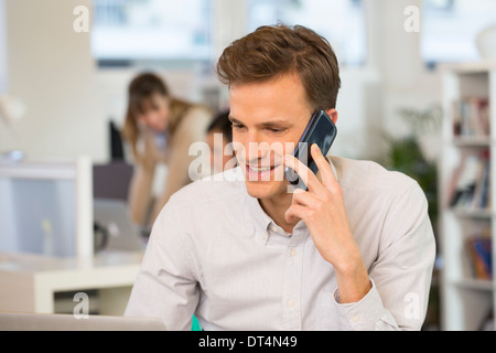 Man Cheerful desk cell phone young Stock Photo