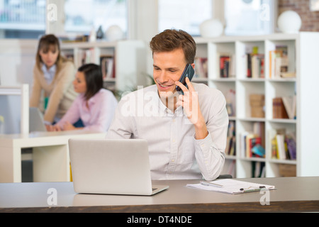 Man Cheerful desk cell phone young Stock Photo