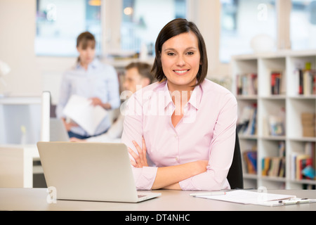 cute female desk laptop colleagues smiling Stock Photo
