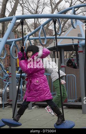 Chinese Child plays during Chinese New Year in a local Chinatown playground in New York City. Stock Photo