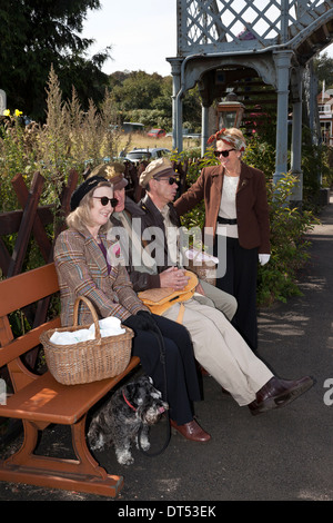 Four people waiting at a railway station in 1940's costume Stock Photo