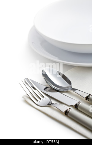 silver cutlery and plates on white background Stock Photo