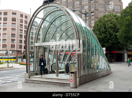 A woman leaves a Bilbao Metro station in Bilbao, Spain, through a 'Fosterito' glass structure named after Sir Norman Foster. Stock Photo