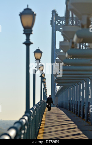 Man, with briefcase, walking across the Ben Franklin Bridge to Philadelphia, Pennsylvania, USA Stock Photo