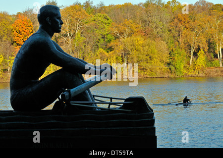 Single sculler passes the statue of John B. Kelly on Kelly Drive in Fairmount Park, Philadelphia, Pennsylvania, United States Stock Photo