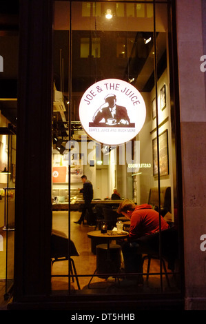 Joe & the Juice bar in London, with young man sitting at window with drink Stock Photo