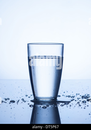 Glass of water with drops on light background Stock Photo