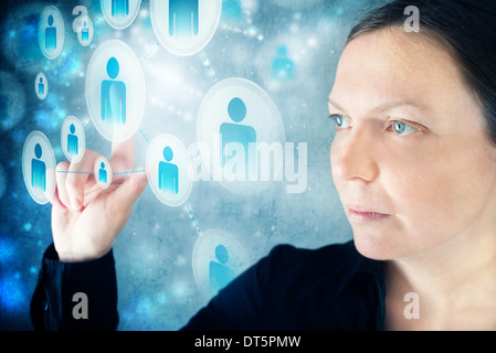 Businesswoman pressing display button on social networking scheme. Concept of modern communication through social networks. Stock Photo
