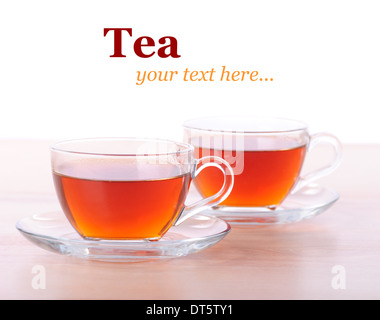 Two glass cups of black tea on wooden table with white background Stock Photo