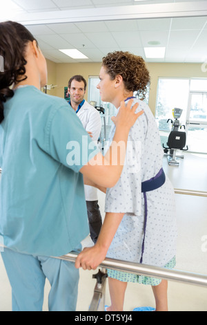 Physical Therapist Assisting Female Patient In Walking Stock Photo