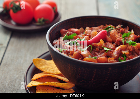 Chili Con Carne in bowl with tortilla chips on wooden background Stock Photo