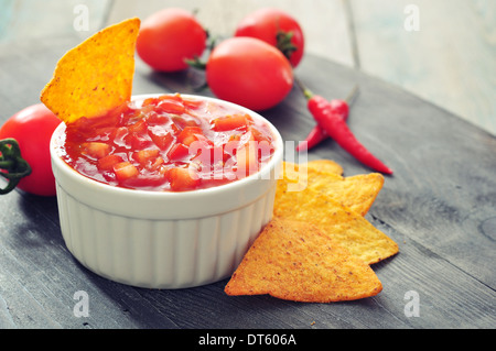 Bowl of salsa with tortilla chips, tomatos and chilli pepper closeup Stock Photo