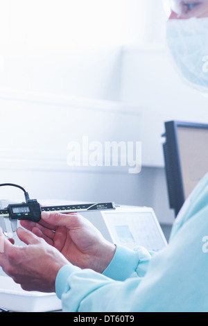 Laboratory technician checking and adjusting equipment reading Stock Photo