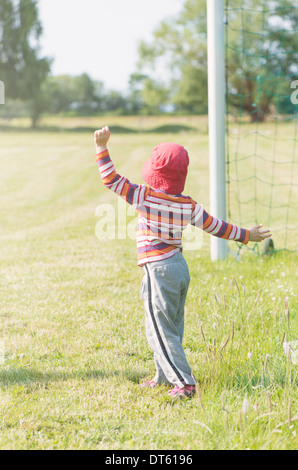 Young girl playing with net of football (soccer) goal Stock Photo