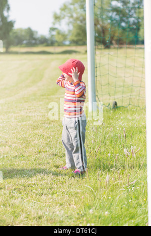 Young girl playing with net of football (soccer) goal Stock Photo