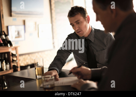 Partners signing business contract in a wine bar Stock Photo