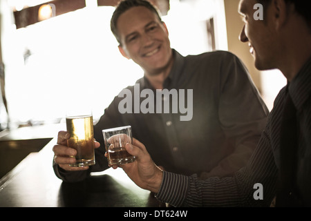 Two businessmen toasting drinks at the bar Stock Photo