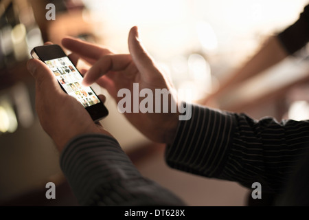 Close up of man using smartphone touchscreen in wine bar Stock Photo