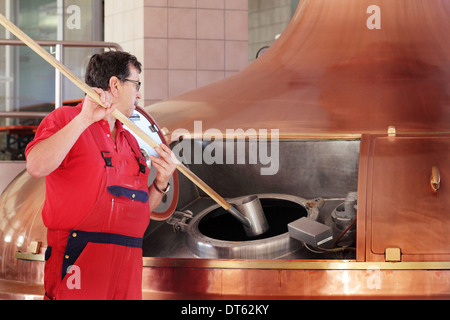Man stirring vat in brewery