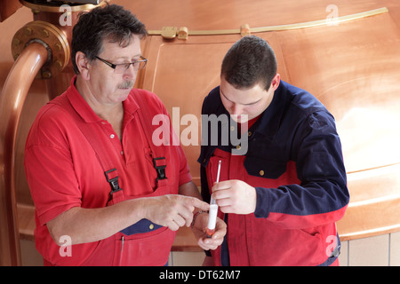 Men checking sample in brewery Stock Photo