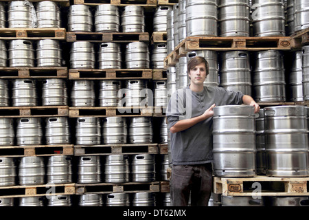 Man leaning on keg in brewery Stock Photo