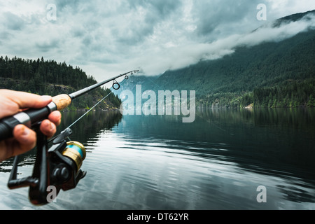 Man holding fishing rod close-up, Buntzen Lake, British Columbia, Canada Stock Photo