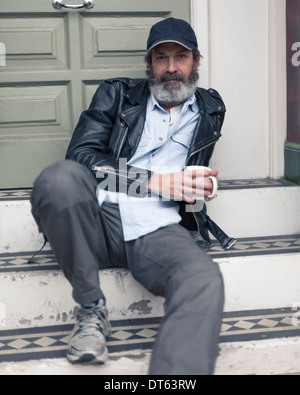 Mature man sitting on steps Stock Photo