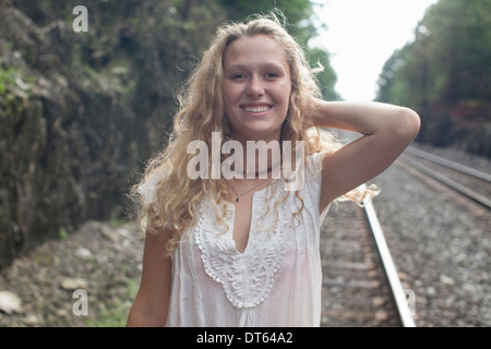 Teenage girl standing by railway track Stock Photo