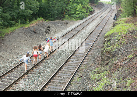 Friends walking on railway track Stock Photo