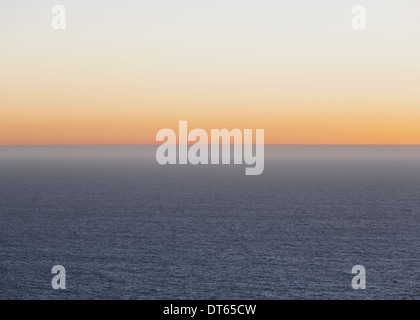 A view over the Pacific Ocean and the sunset on the horizon. Stock Photo