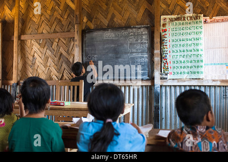 Bangladesh, South Asia, Chittagong, Boy writing Bangladeshi on the blackboard in a UN supported rural primary school classroom. Stock Photo