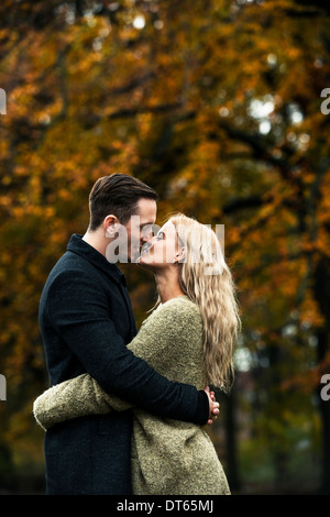 Young couple hugging and kissing in woods Stock Photo