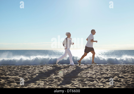 Couple jogging on beach Stock Photo