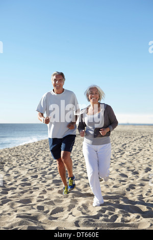 Couple jogging on beach Stock Photo