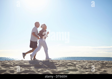 Couple jogging on beach Stock Photo