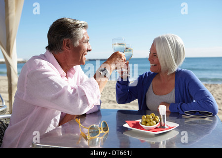 Couple enjoying wine by seaside Stock Photo