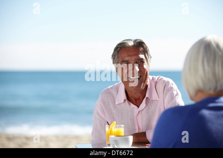 Couple enjoying wine by seaside Stock Photo