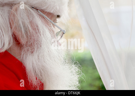 Santa Claus looking out of window Stock Photo