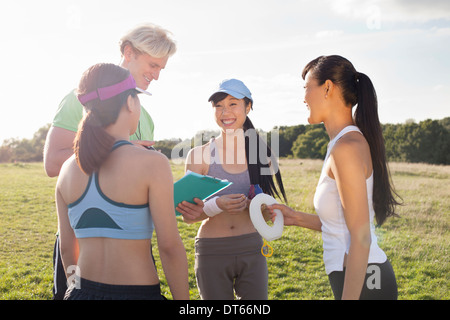Personal trainer giving instruction to group of clients Stock Photo