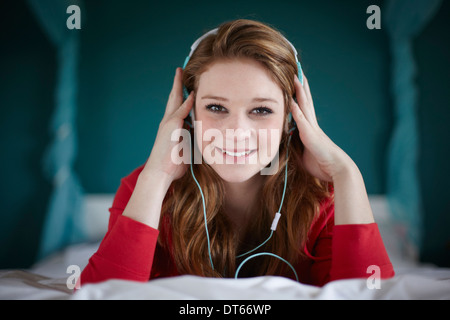 Portrait of teenage girl in bedroom listening to music Stock Photo