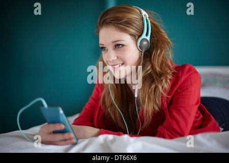 Teenage girl in bedroom listening to music Stock Photo