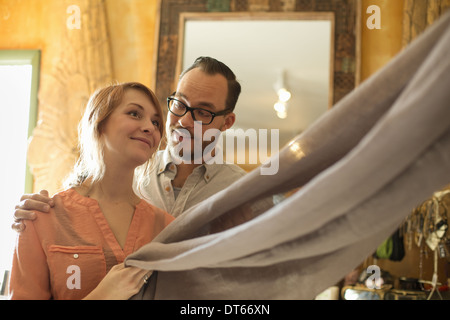Two people, a couple running an antique store. Small business. Holding a piece of linen fabric. Stock Photo