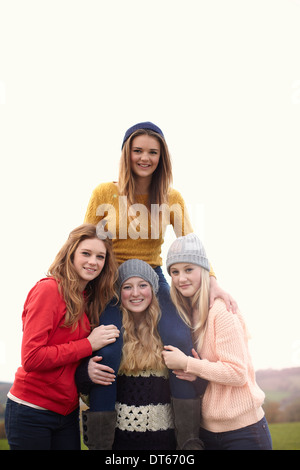 Teenage girl getting shoulder ride from friends Stock Photo