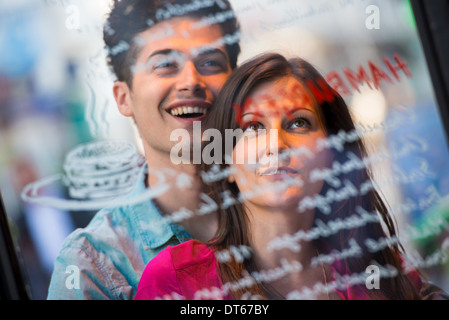 Young couple reading cafe window menu, Paris, France Stock Photo