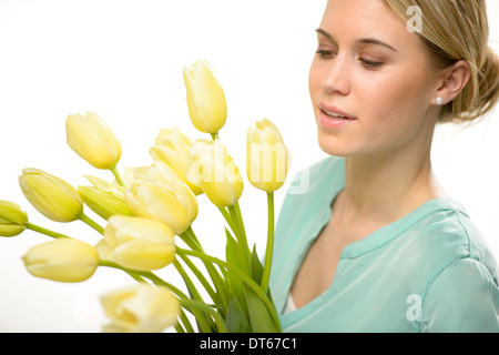 Woman looking down yellow tulip spring flowers isolated on white Stock Photo